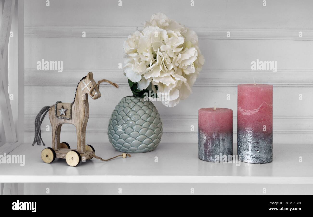 Home accessori vaso di legno cavallo e candele su legno bianco ripiano Foto Stock