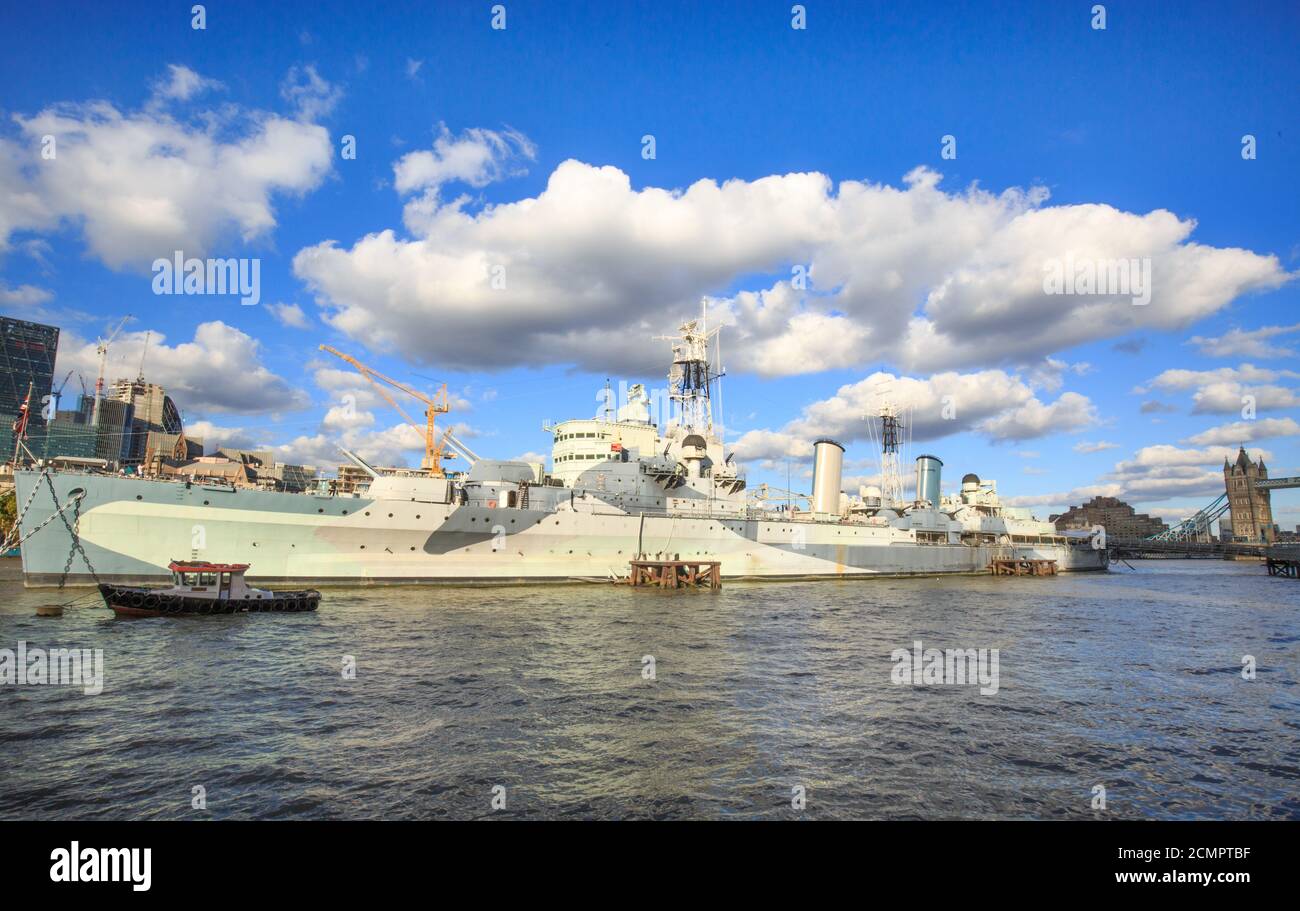 HMS Belfast ormeggiato sul fiume Tamigi a Londra con un bel blu cloudscape. Si tratta di una popolare attrazione turistica ed è aperto al pubblico. Londra Foto Stock