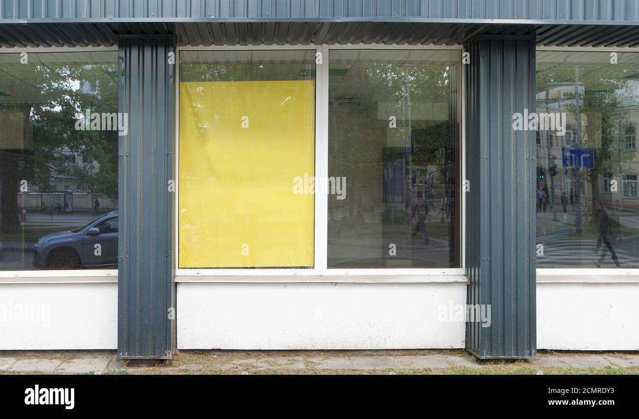 La vita di strada si riflette nelle finestre di vetro di un negozio chiuso in bancarotta. Foto Stock