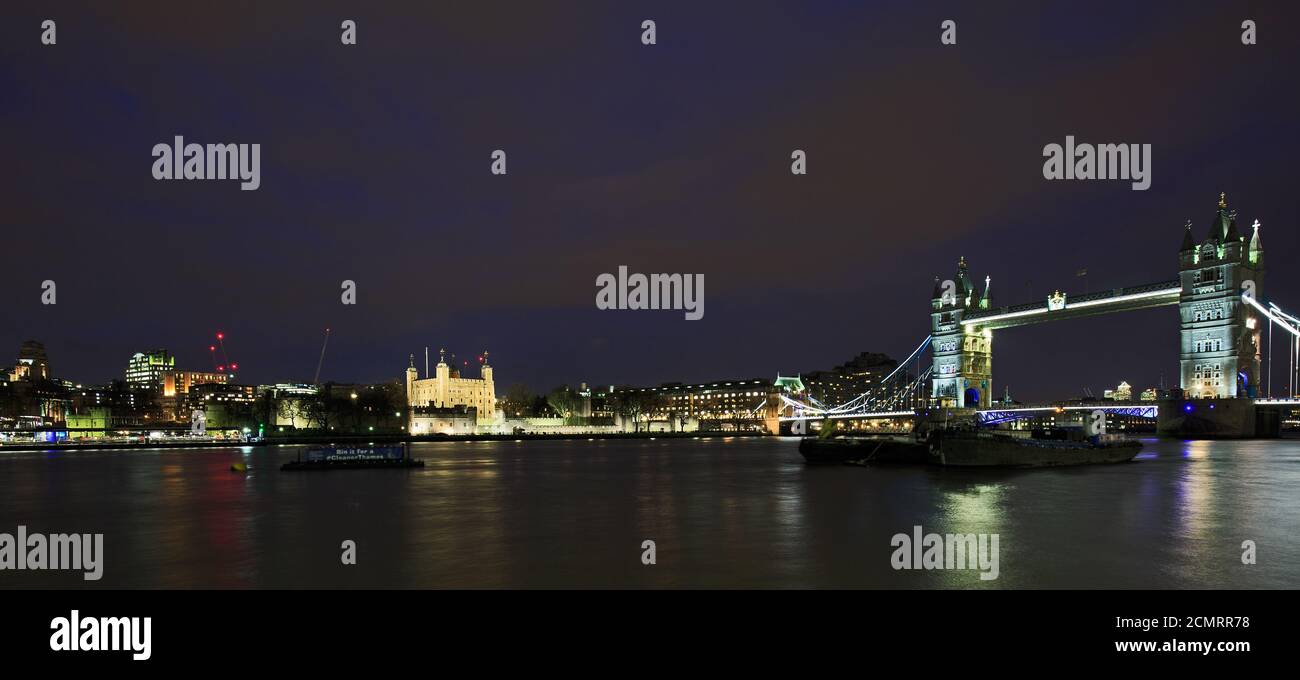 Tower Bridge che attraversa il Tamigi illuminato di notte. Si trova nella Citta' di Londra ed e' una delle principali attrazioni turistiche Foto Stock