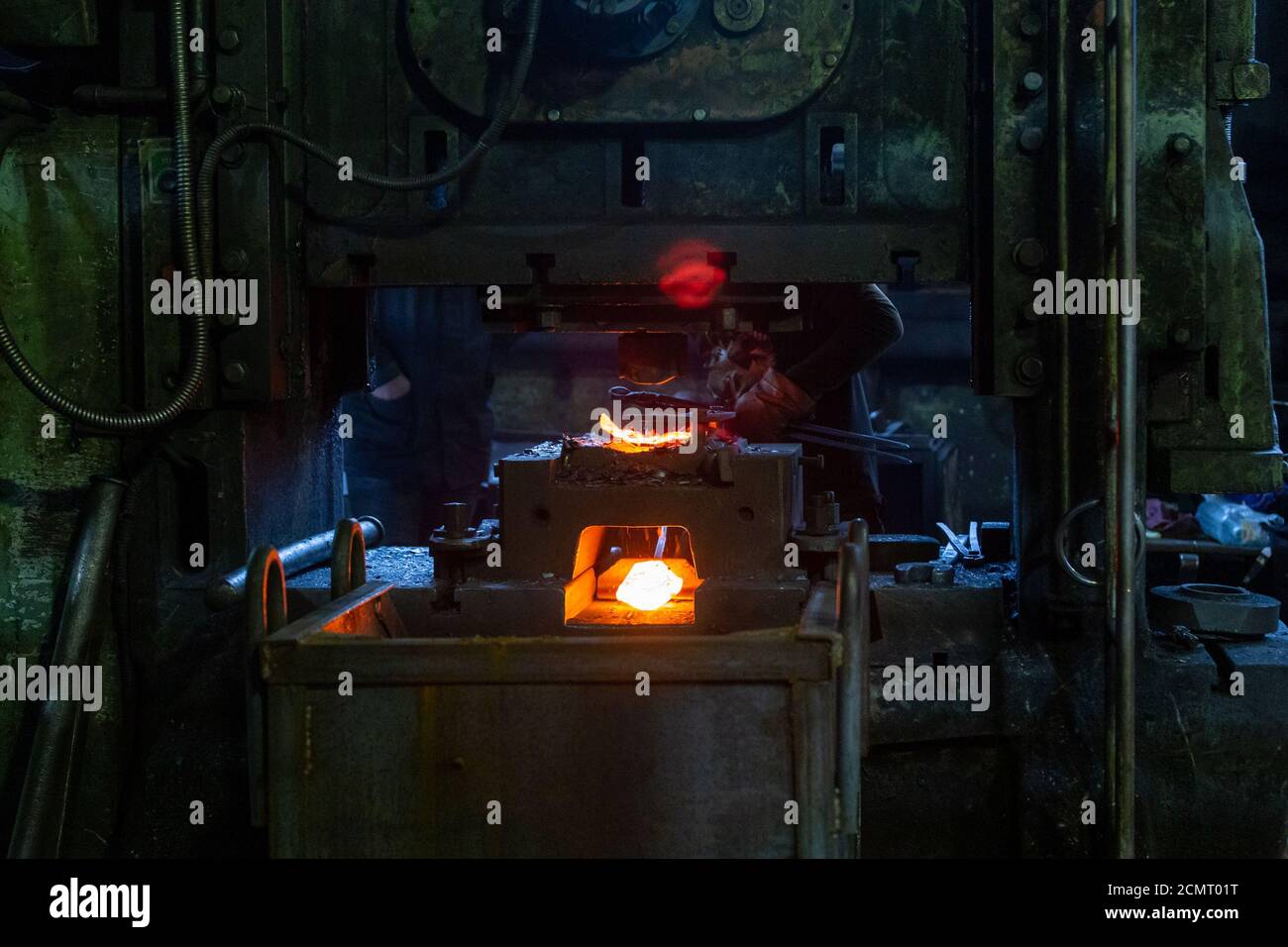 immagine ravvicinata di pezzi in acciaio caldo forgiati dopo la stampa formazione in fabbrica sporca scura Foto Stock