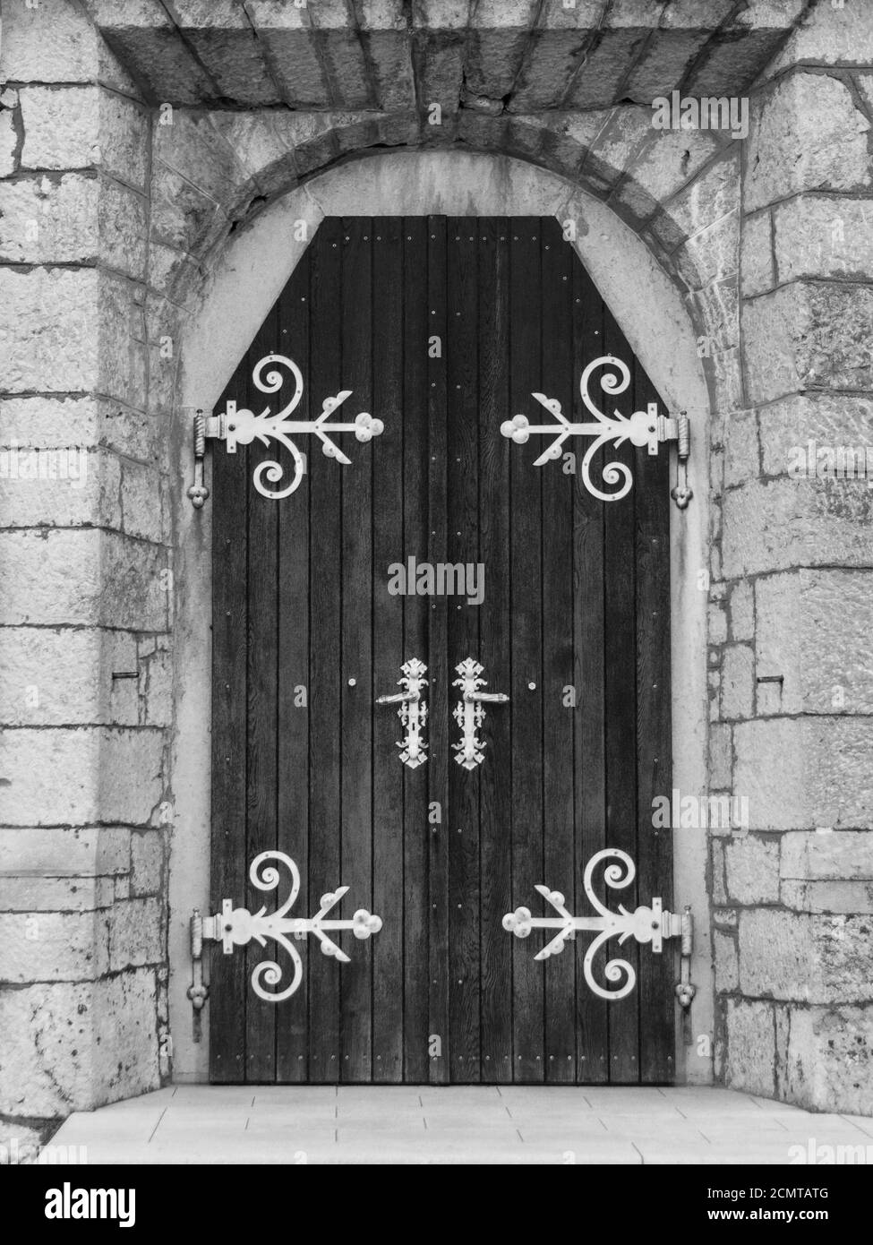 Vecchia porta in legno con bel portale in pietra, immagine in bianco e nero Foto Stock