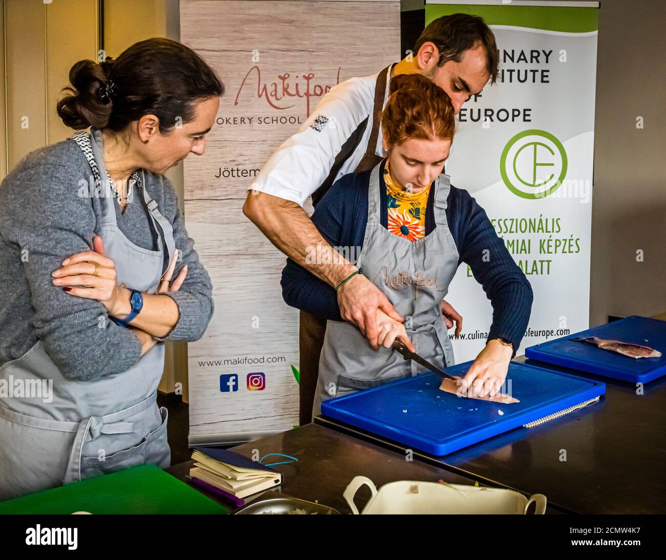 Come si raccorda una trota? Laszlo Papdi spiega la tecnica di taglio in cucina durante un corso presso l'Istituto culinario di Budapest, Ungheria Foto Stock