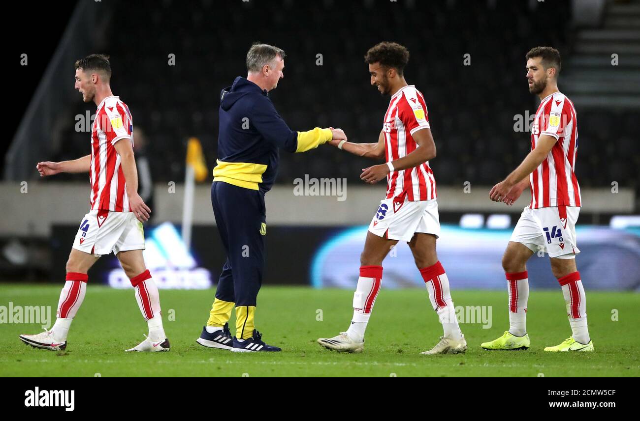 Michael o'Neill (secondo a sinistra), manager di Stoke City, scuote le mani con Jacob Brown dopo la seconda partita della Carabao Cup a Molineux, Wolverhampton. Foto Stock