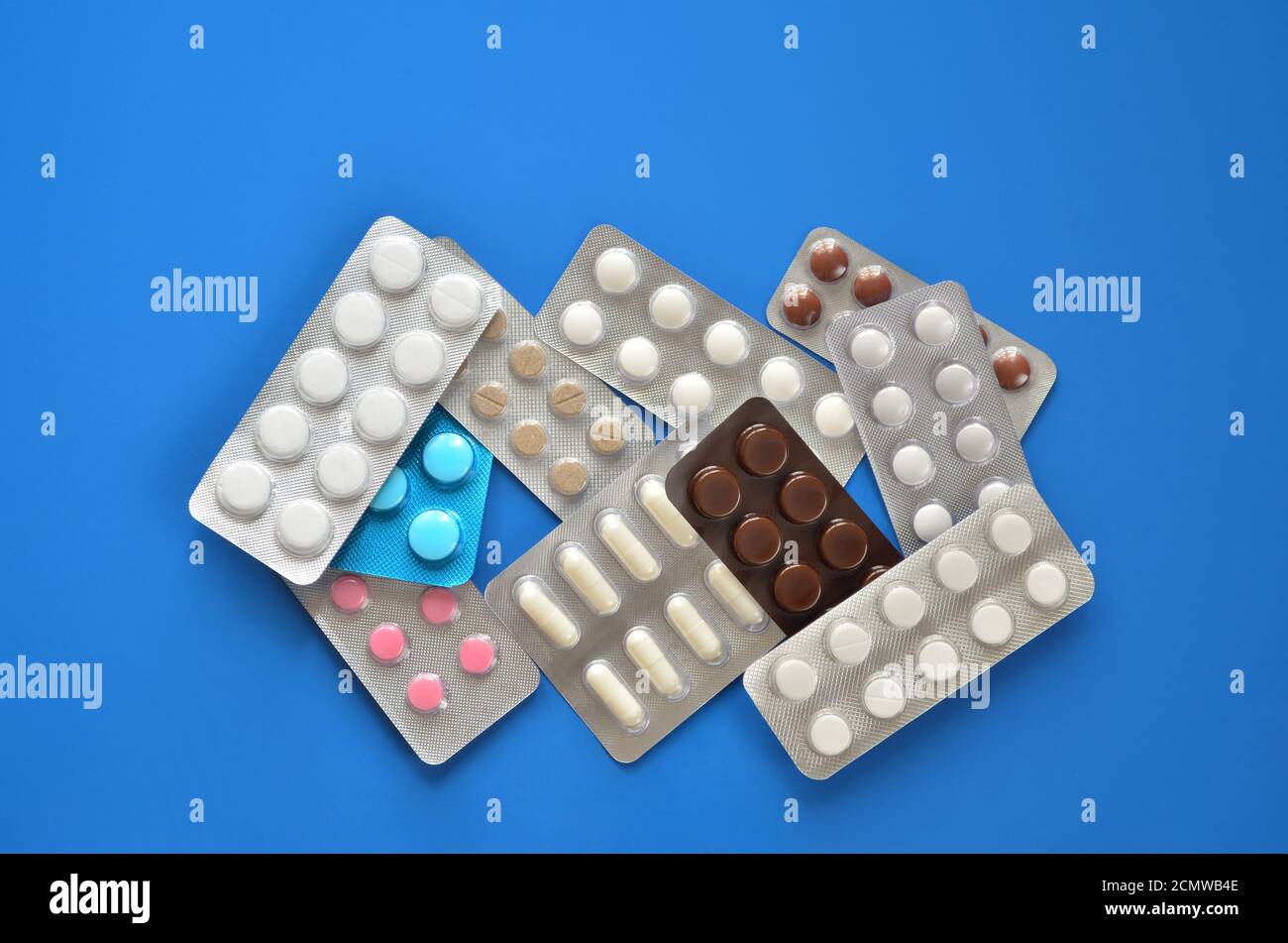 Raccogliere varie pillole in blister confezione su uno sfondo blu primo piano, piatto posa. Concetto di assistenza sanitaria. Foto Stock