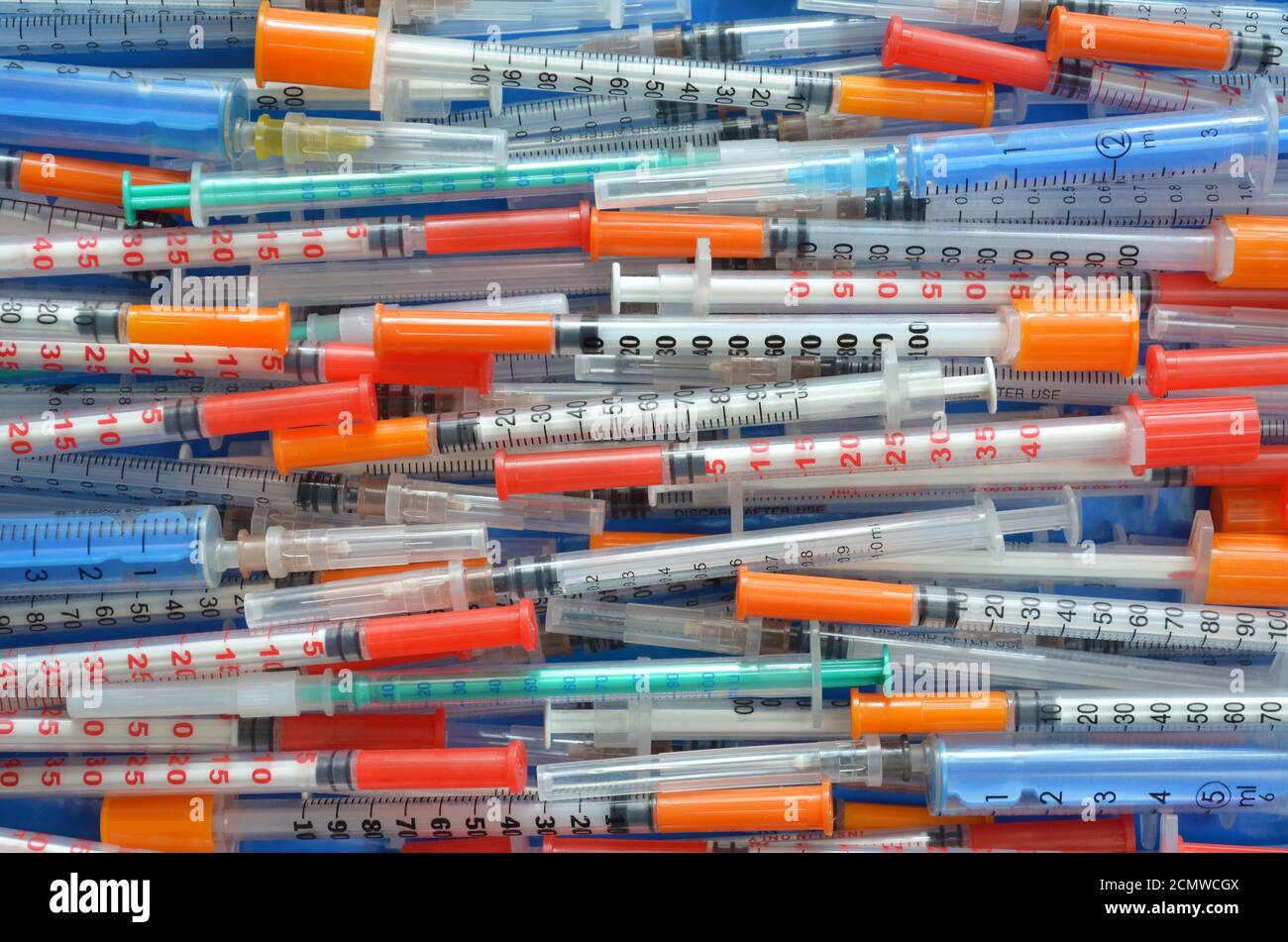 Molte diverse siringhe per insulina da vicino monouso disposte orizzontalmente come sfondo, vista dall'alto. Concetto di assistenza sanitaria. Foto Stock