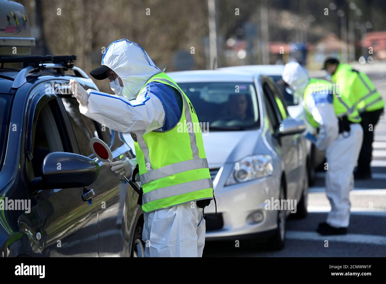 Gli agenti di polizia in tute protettive parlano con persone all'interno di automobili al confine slovacco-ceco a Drietoma Crossing, Slovacchia, 13 marzo 2020. REUTERS/Radovan Stoklasa Foto Stock
