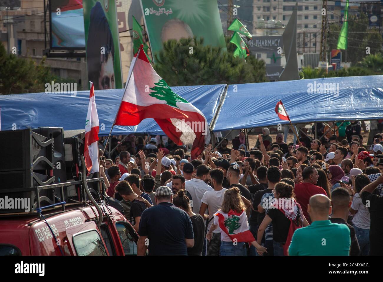 Manifestanti libanesi che innalzano la Bandiera del Libano nel cielo al Rivoluzione contro il governo Foto Stock