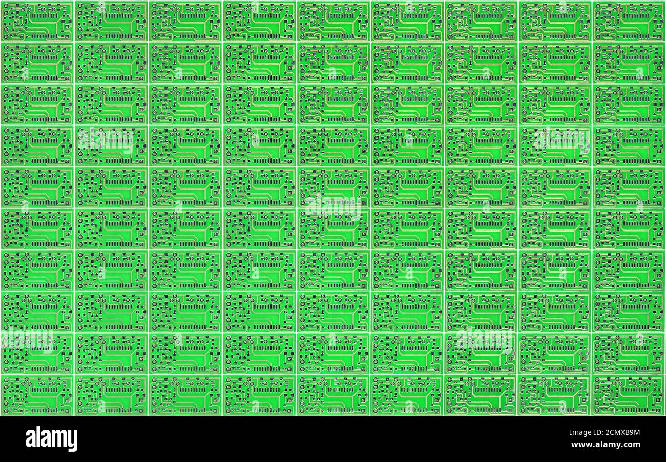 Schede a circuito stampato di piccole dimensioni moltiplicate su un circuito stampato a foglio verde solido come sfondo, concetto per lo sviluppo di circuiti elettronici. Foto Stock