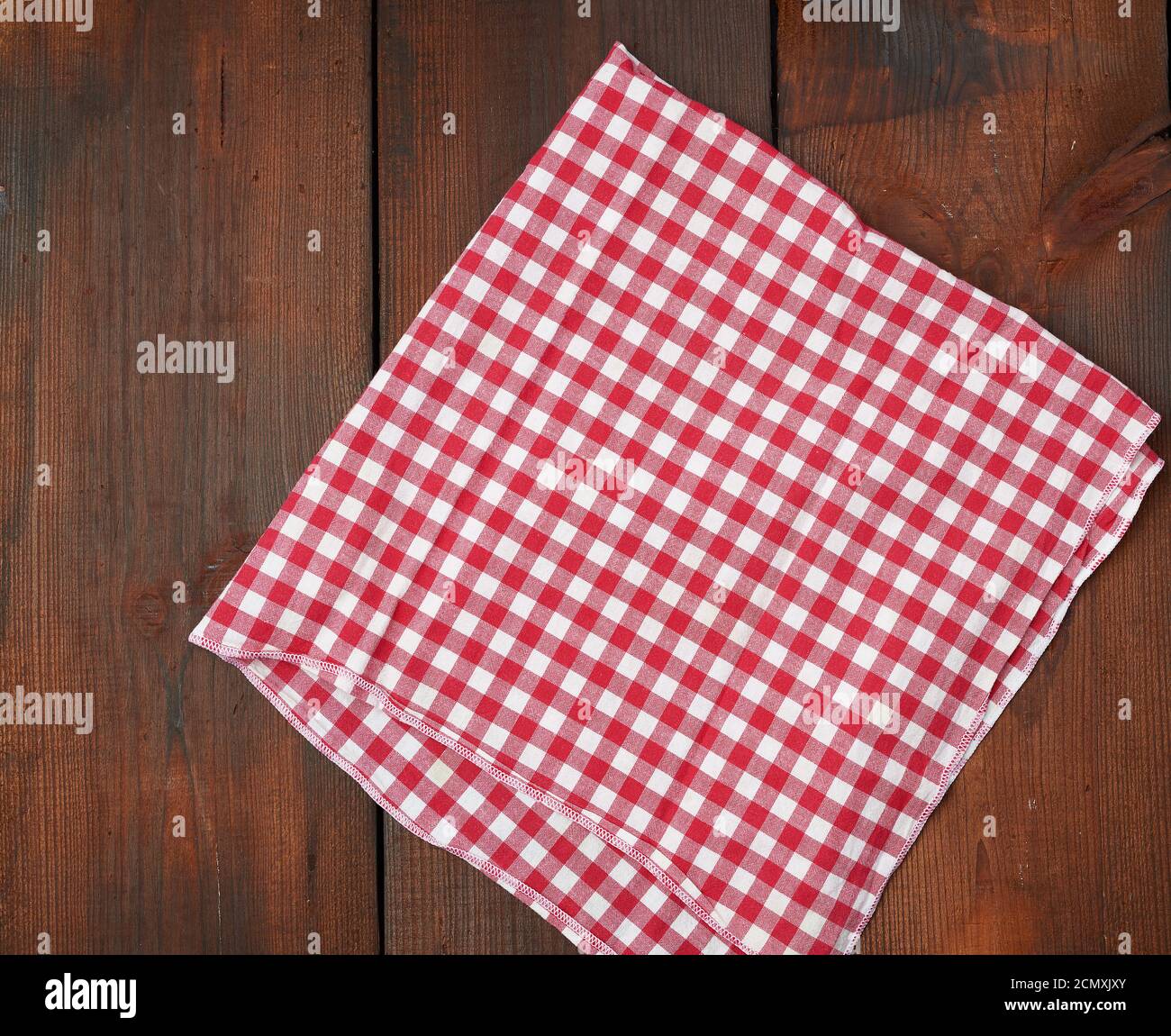 asciugamano da cucina bianco rosso scacchiato su sfondo di legno marrone Foto Stock