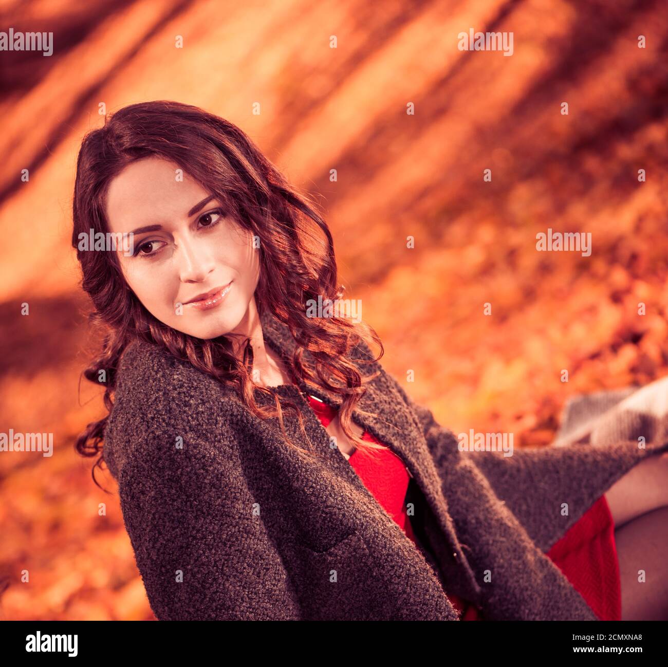 Giovane bella donna in cappotto a autunno sfondo colorato Foto Stock