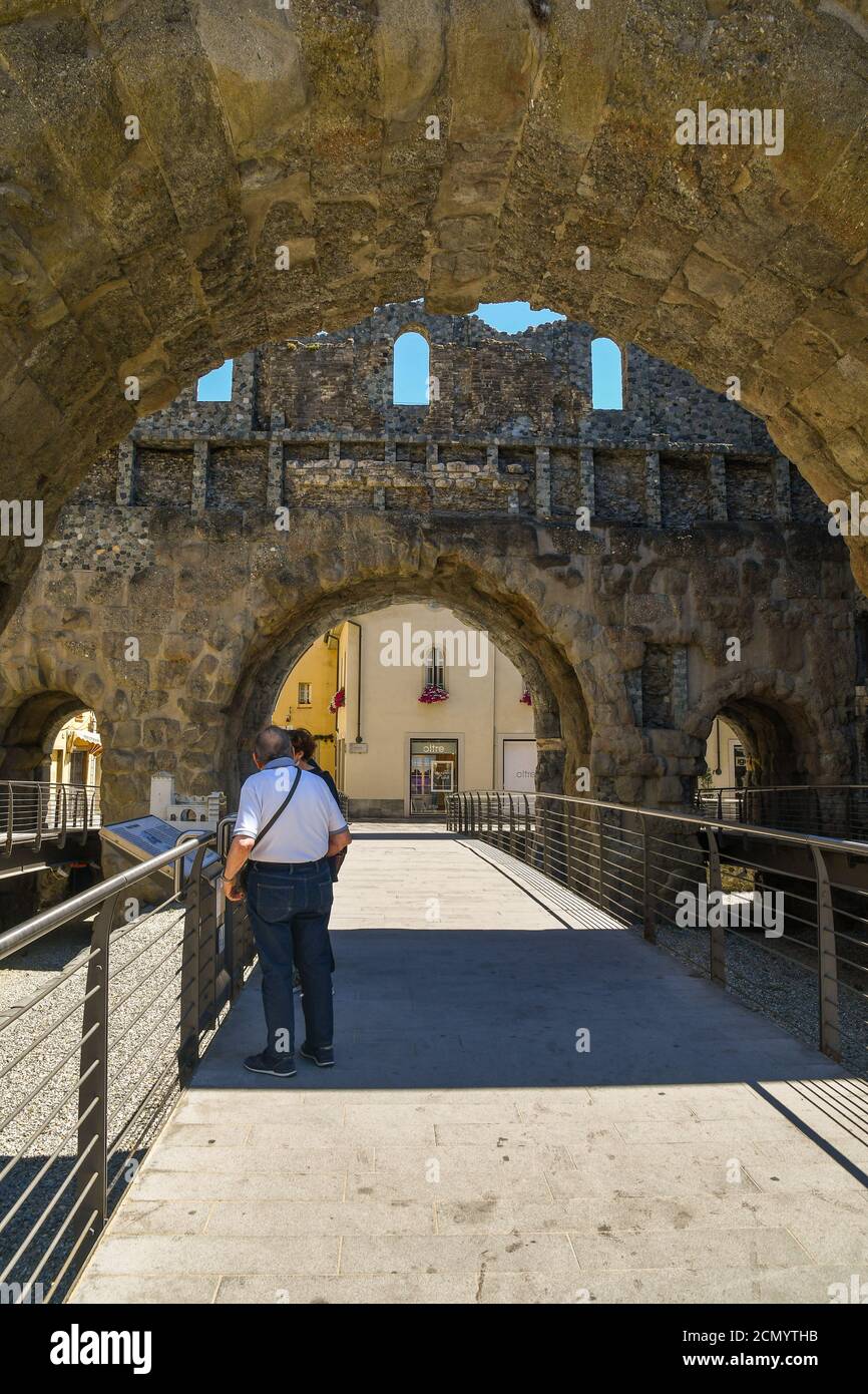 Un paio di turisti che guardano al modello tattile della porta Pretoria di epoca romana (25 a.C.), utile alla fruizione dei ciechi, Aosta, Italia Foto Stock