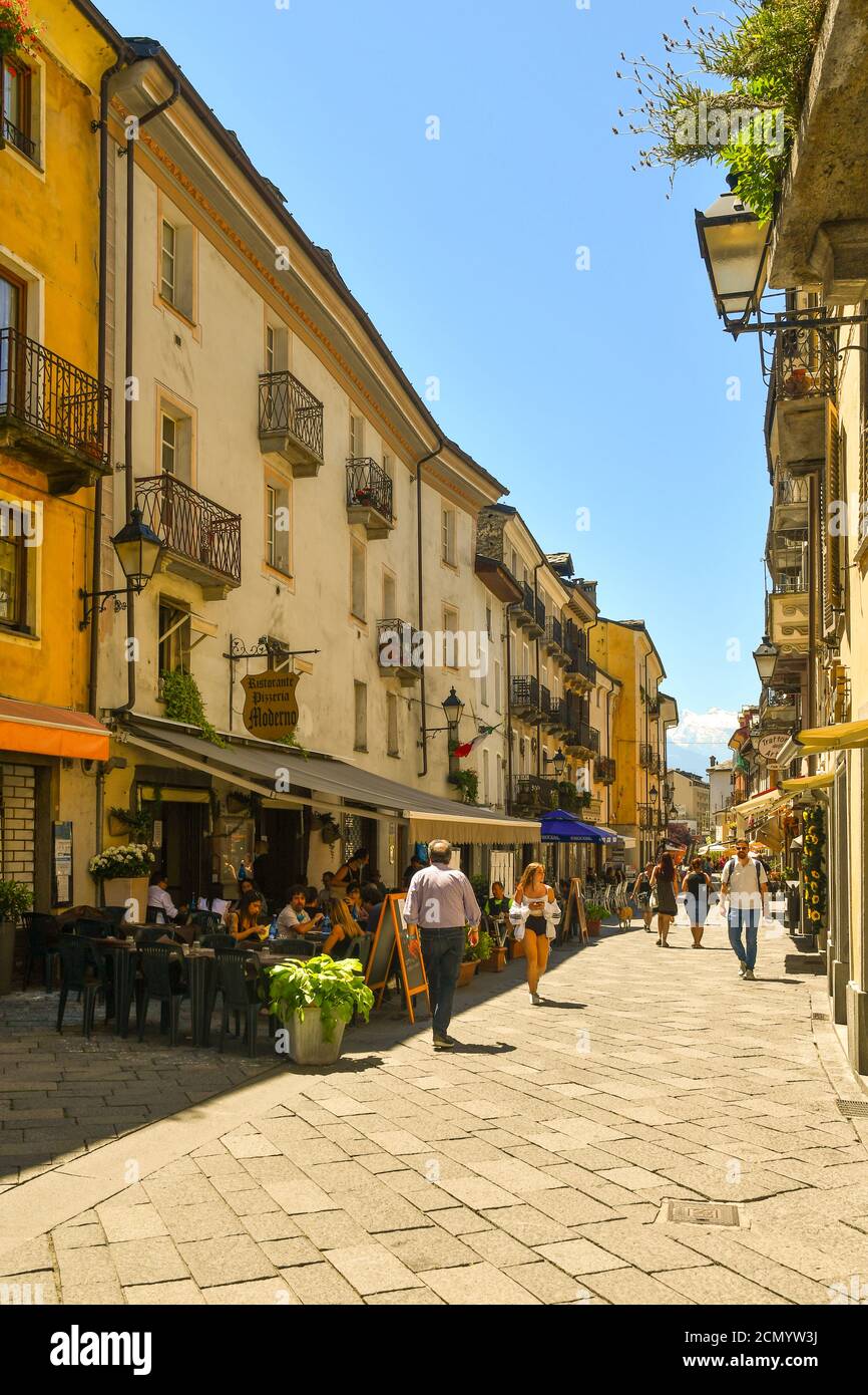 Vista di un vicolo pedonale nel centro storico della città alpina con caffè all'aperto e persone in estate, Aosta, Valle d'Aosta, Italia Foto Stock