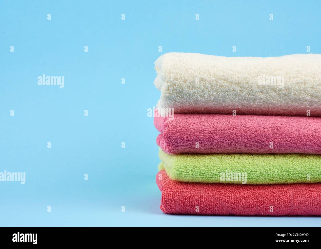 stack di asciugamani piegati in spugna di cotone colorato su un blu sfondo Foto Stock