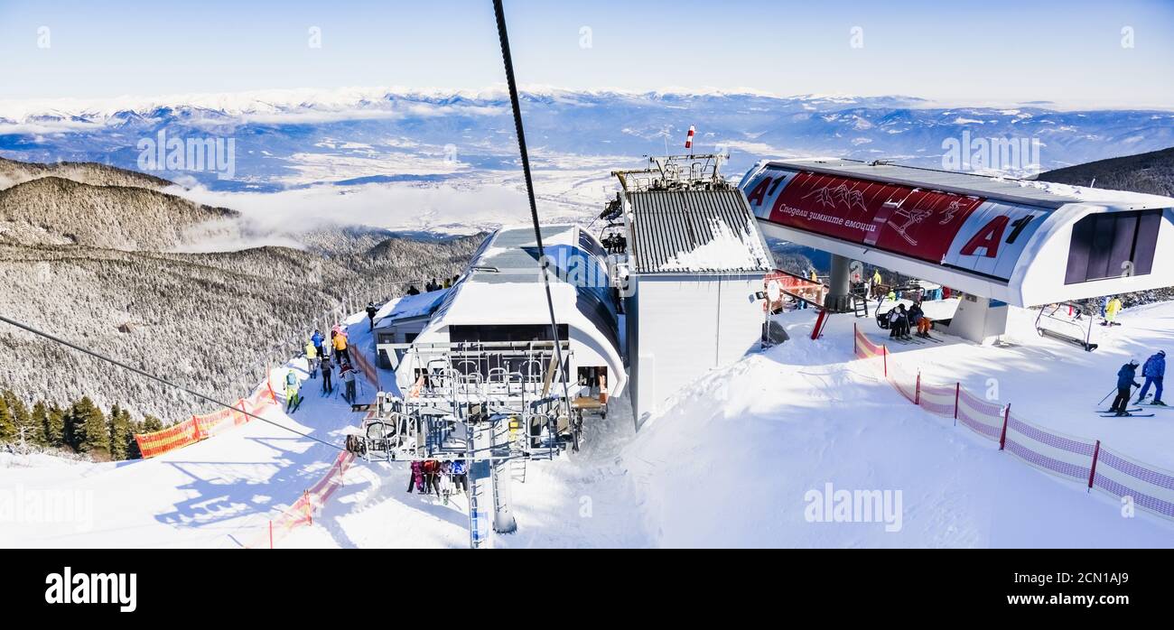 Piste da sci innevate e stazione di skilift per seggiovie in località sciistica di montagna. Foto Stock