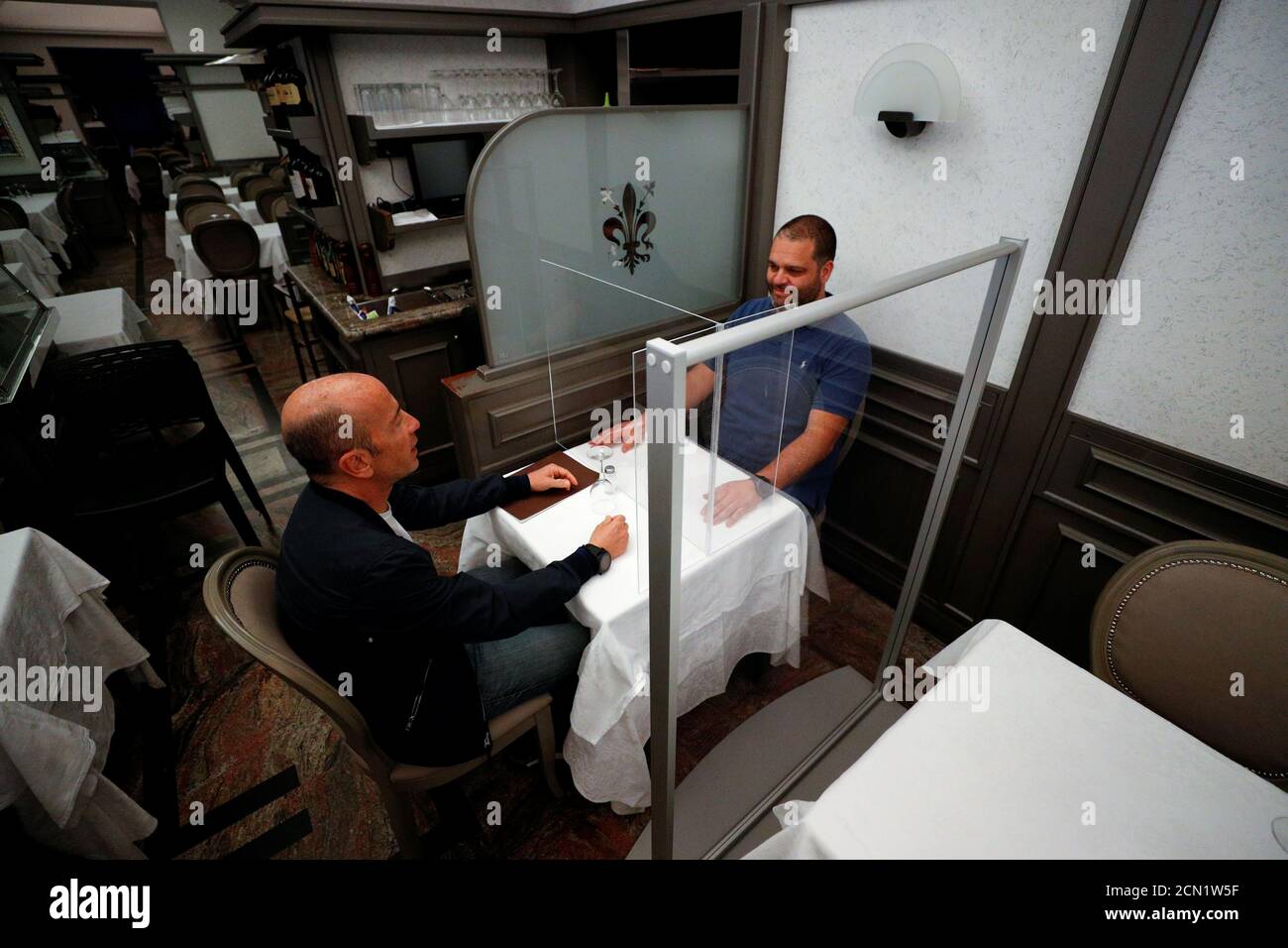 Alberto Iannelli e Fabio Andreotti, proprietari del ristorante Nuova  Fiorentina, testano lo schermo protettivo in plexiglass che è stato  installato in un tavolo, mentre continua a diffondersi la malattia del  coronavirus (COVID-19),