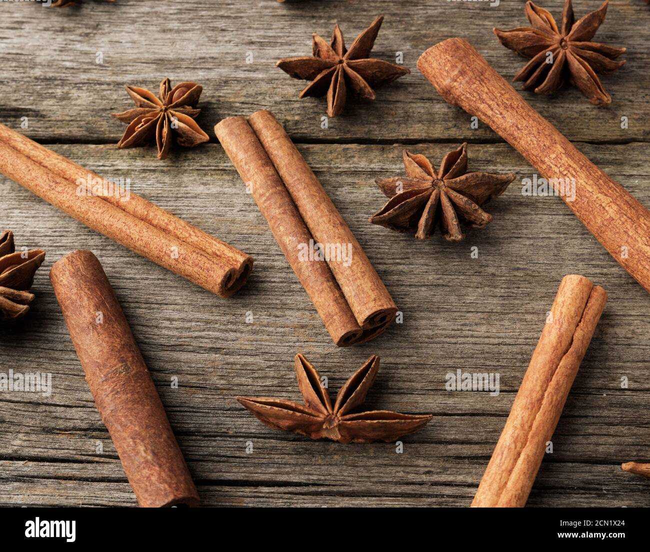 bastoncini di cannella marroni e anice stellato asciutto su un grigio sfondo di legno Foto Stock