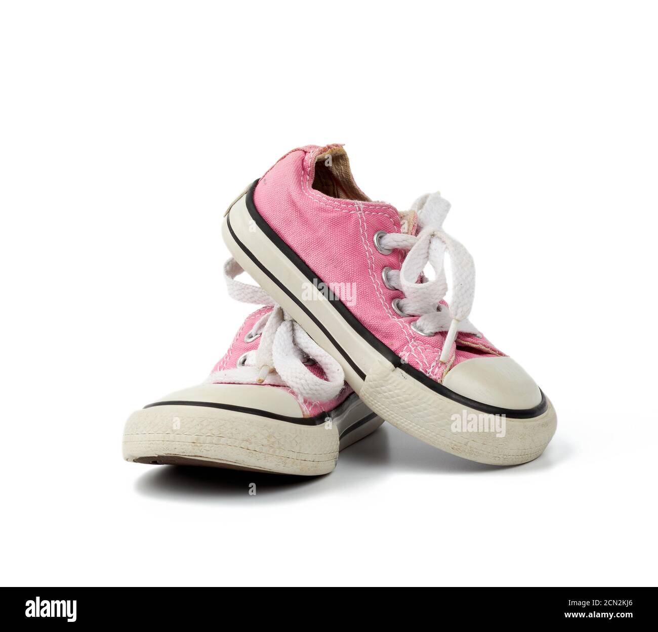 paio di sneakers rosa per bambini in tessuto con lacci bianchi isolati su sfondo bianco Foto Stock