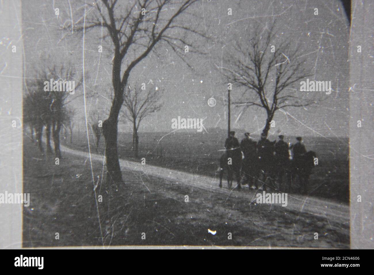 Bella fotografia in bianco e nero degli anni '70 di cinque uomini su cavalli che trottano lungo un percorso di campagna. Foto Stock