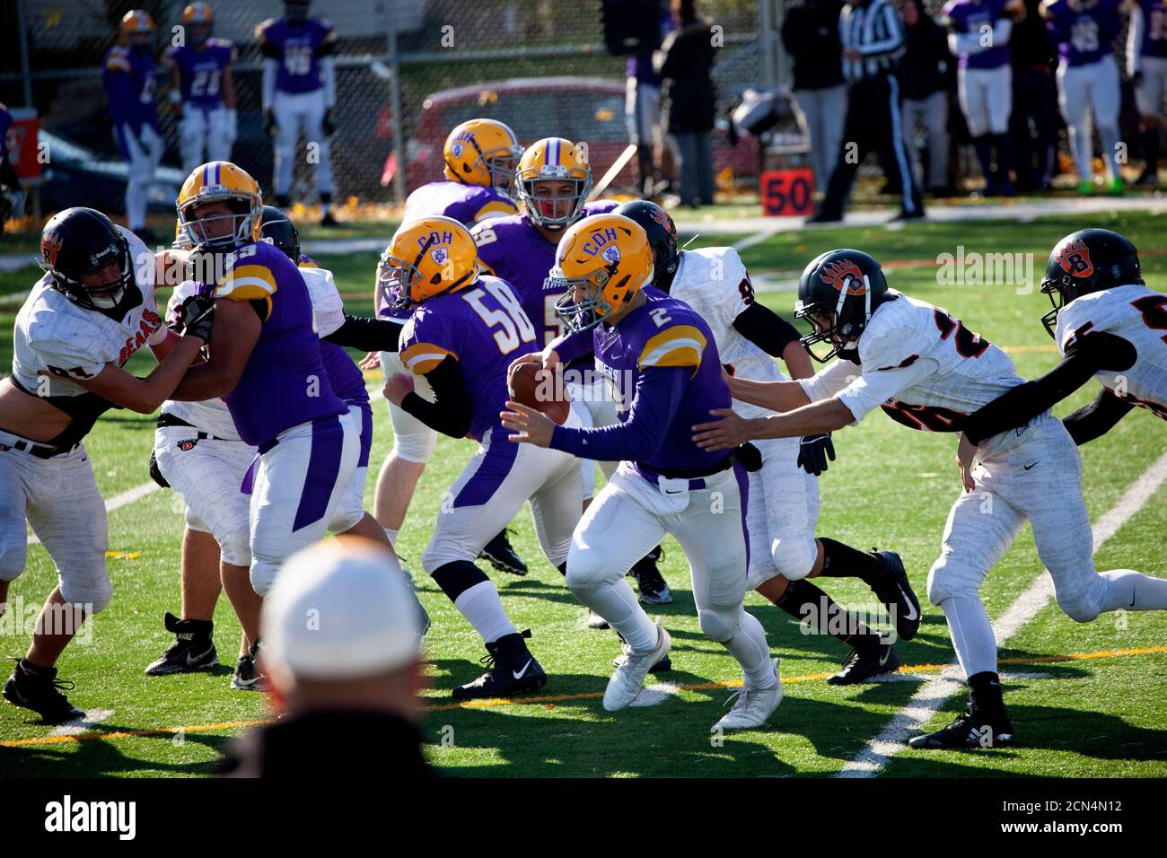 Il quarterback delle scuole superiori intrappolato dietro la linea dello scarabeo dalla difesa e presto essere affrontato. Minneapolis, Minnesota, Stati Uniti Foto Stock