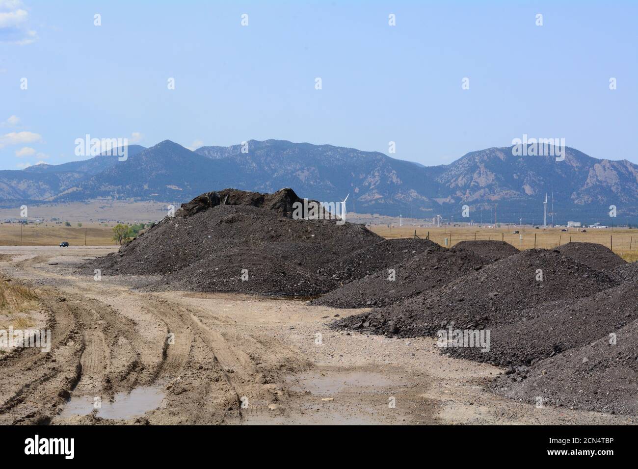 Pile di asfalto riciclato e bitume da riciclare per Fare strade con le Montagne Rocciose in background Foto Stock