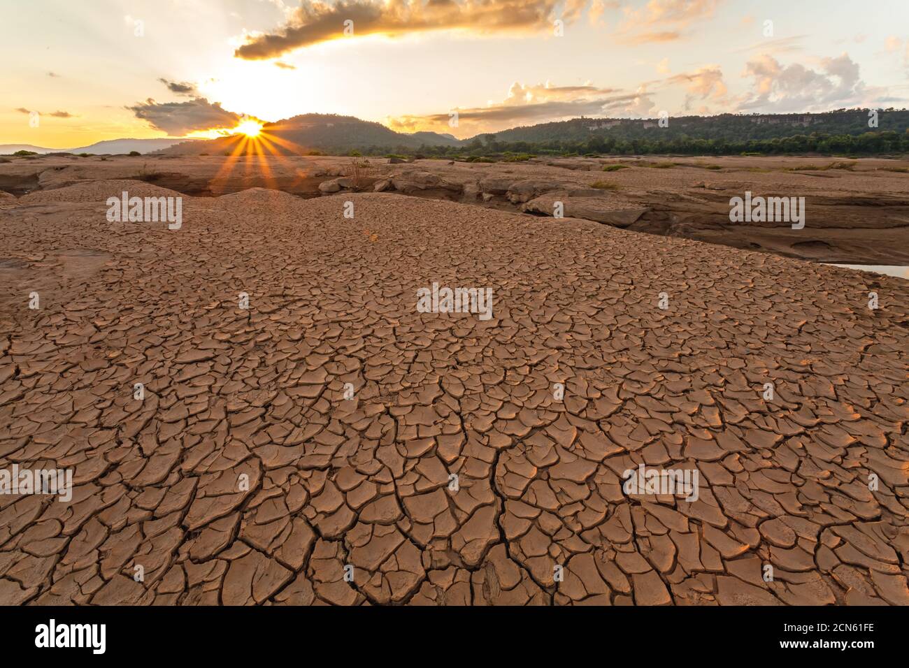 Terra spaccata vicino all'acqua di essiccazione al crepuscolo a Sam Pan Bok nel fiume Mekong. Provincia di Ubonratchathani, Thailandia Foto Stock