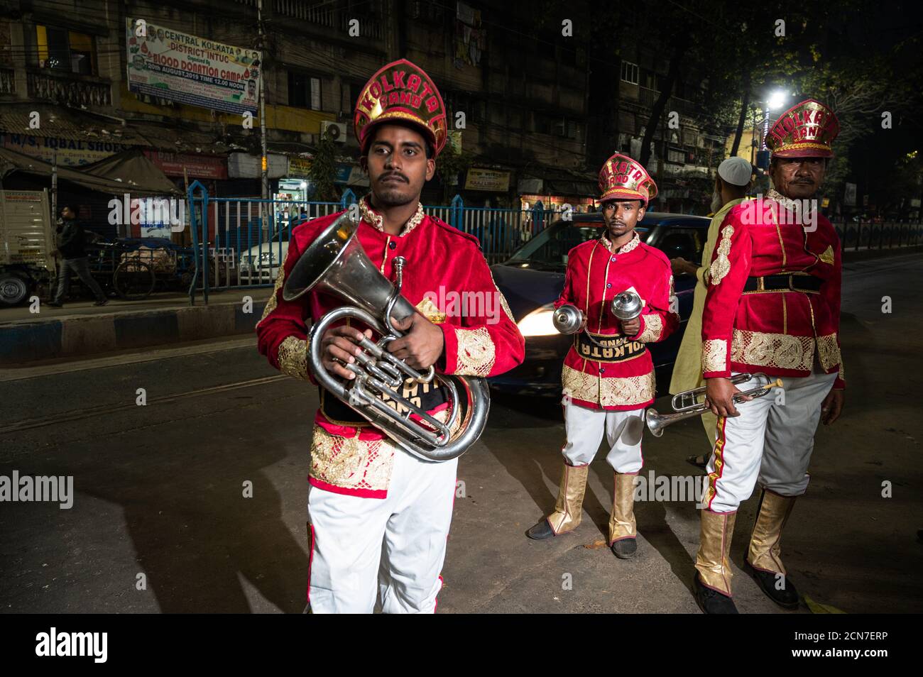 Tre musicisti indiani di gruppo di nozze che praticano la loro routine musicale quotidiana in serata su strada a Kolkata, India. Foto Stock