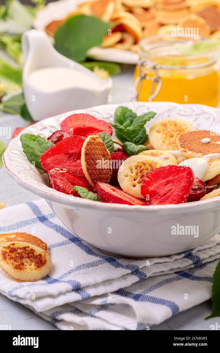 Porridge di minuscoli pancake con frutti di bosco. Cibo alla moda. Foto Stock