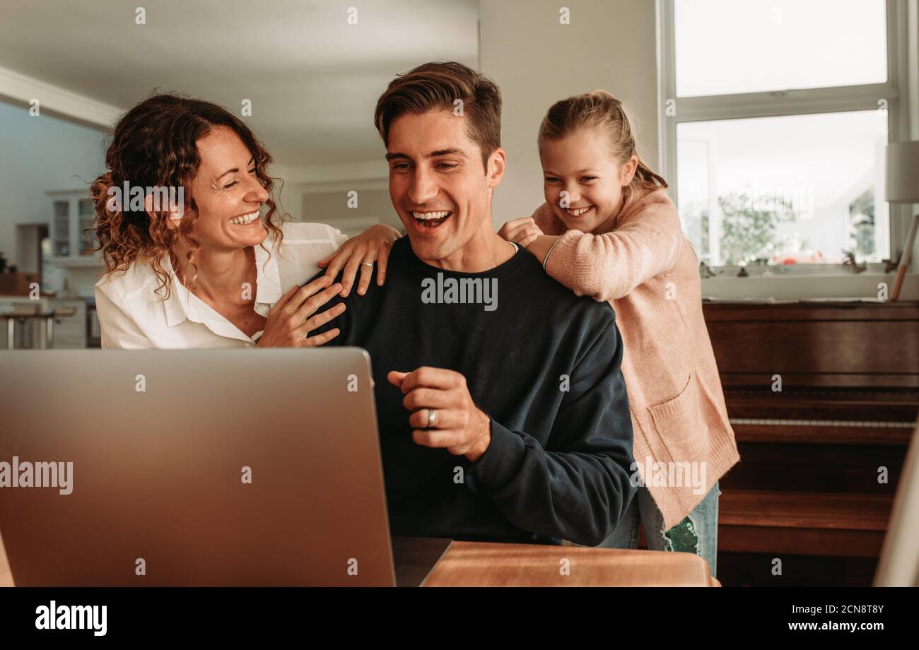 Videochiama la tua famiglia mentre sei a casa. Accoppia con la figlia seduto davanti al computer portatile per effettuare una videochiamata. Foto Stock