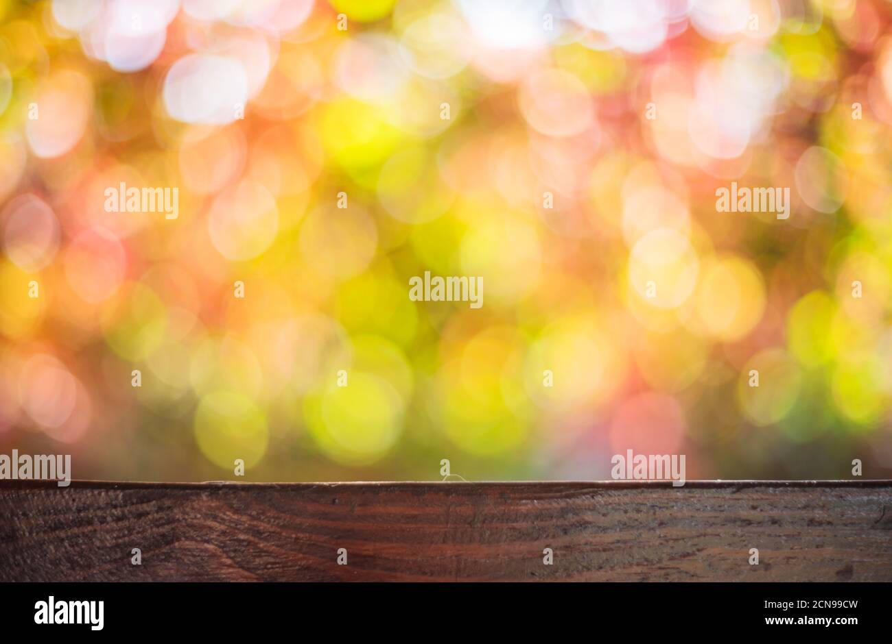 Autunno sfondo con un tavolo in legno e bella e soleggiata bokeh di fondo. Foto Stock