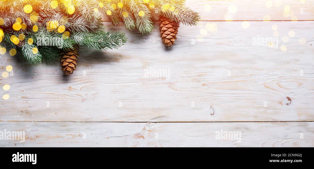 Ramo di abete innevato con coni di abete su tavola di legno. Natale o Capodanno sfondo vacanza. Vista dall'alto. Foto Stock