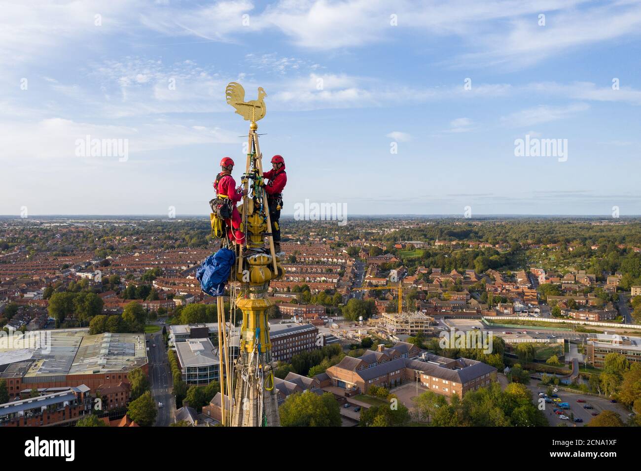 Chris Milford, 72 anni, e il figlio Sam, dello storico specialista della conservazione degli edifici WallWalkers, reinstallano il rubinetto d'acqua in cima alla guglia della cattedrale di Norwich dopo che è stato risaltato come parte dei lavori di restauro sulla guglia che si erge a oltre 312ft di altezza. Foto Stock