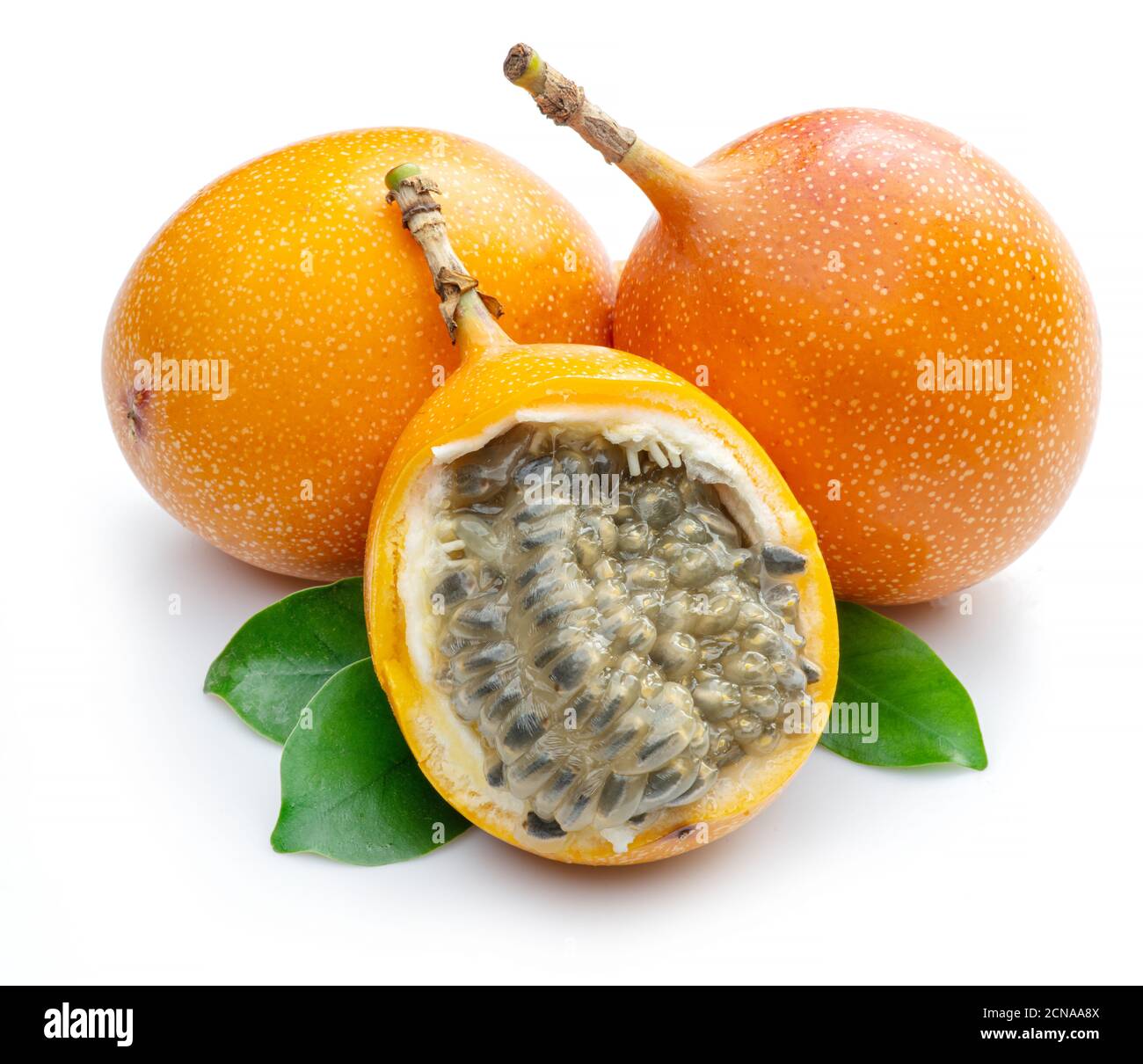 Granadilla con foglie e frutto della passione a metà isolato su sfondo bianco. Foto Stock