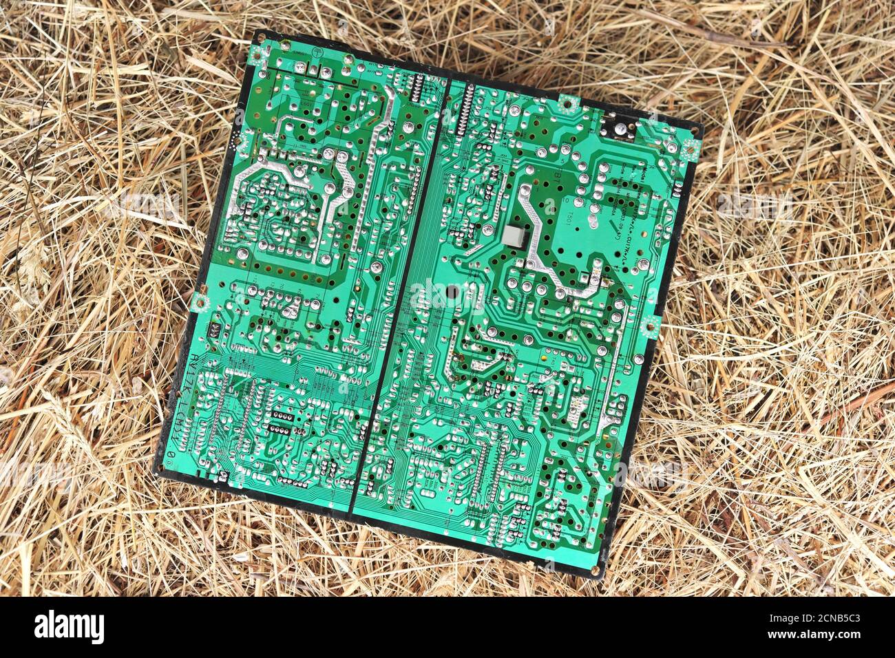 Regione di Chernihiv, Ucraina, 7 maggio 2019. Un vecchio circuito stampato di computer si trova su un mucchio di fieno. Foto Stock
