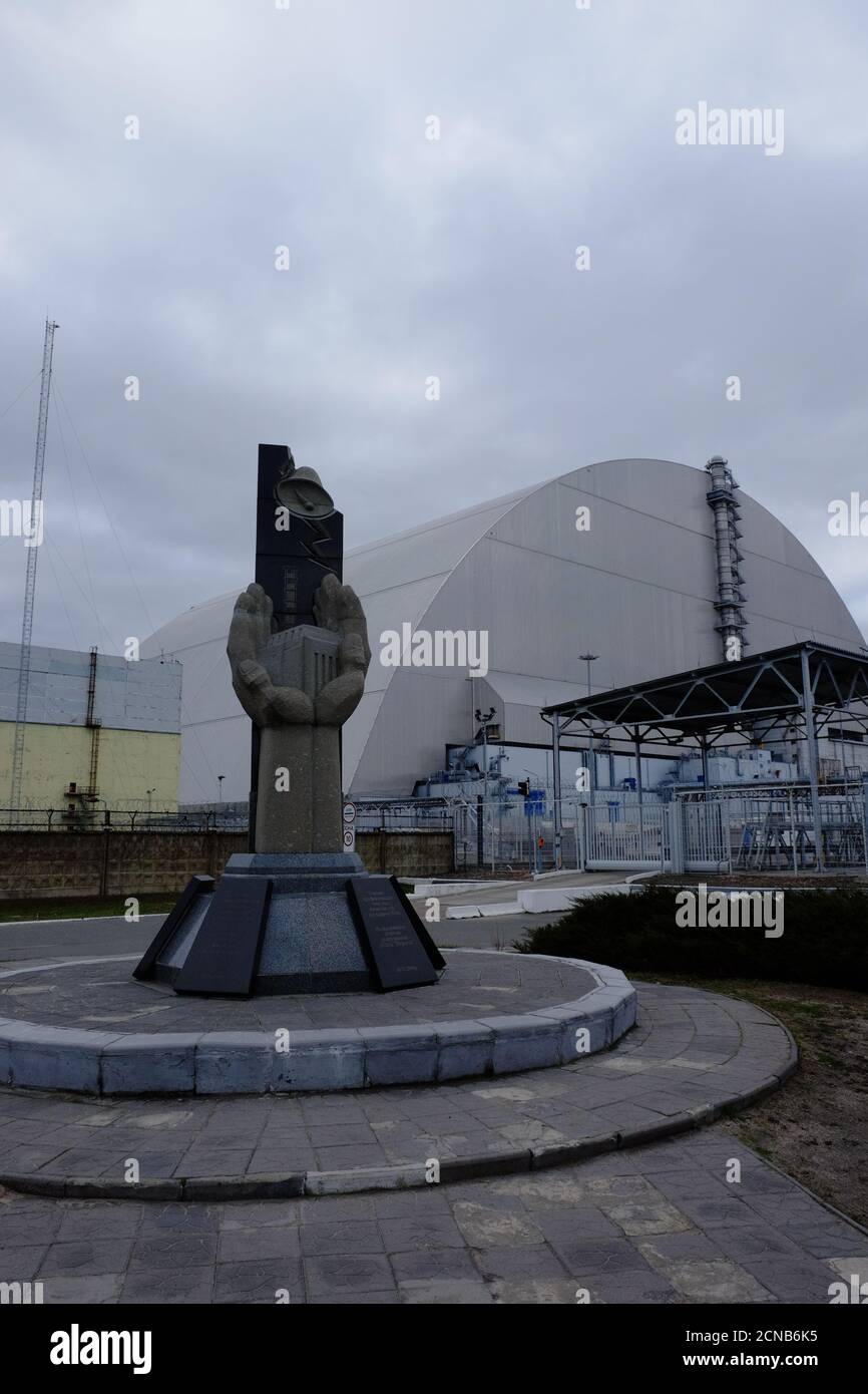 Pripyat, Ucraina, 14 marzo 2020. Monumento ai liquidatori dell'incidente alla centrale nucleare di Chernobyl sullo sfondo di una protezione Foto Stock