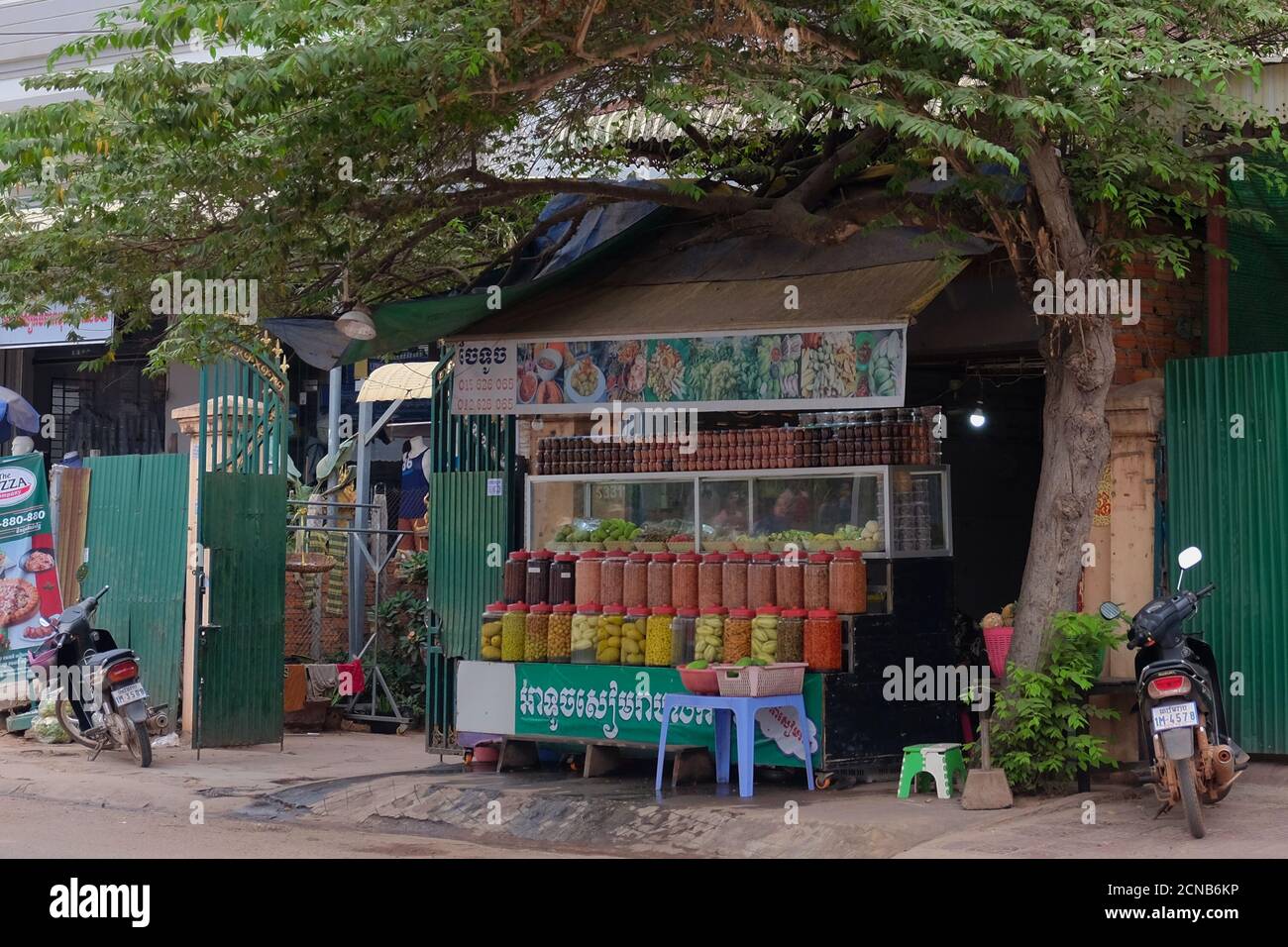 Cambogia, Siem Reap 12/08/2018 commercio di strada di spezie esotiche e frutta, un sacco di vasi multicolore con spezie, un albero vicino al chiosco Foto Stock