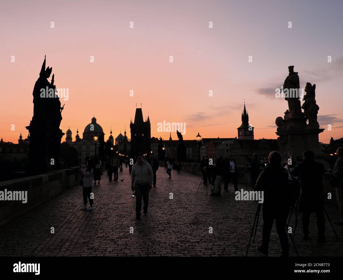 Praga, Repubblica Ceca, 13 ottobre 2019. Turisti sul Ponte Carlo all'alba. Sagome di edifici medievali. Foto Stock