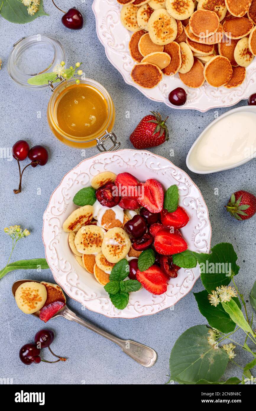 Porridge di minuscoli pancake con frutti di bosco, crema e miele. Foto Stock