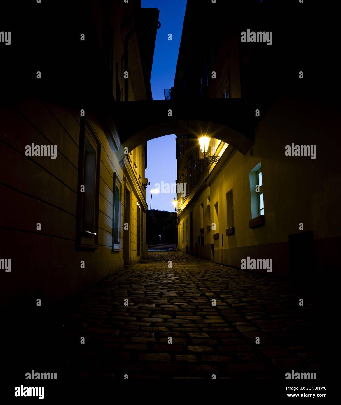 Strada notturna della vecchia Praga sotto la luce delle lanterne Foto Stock