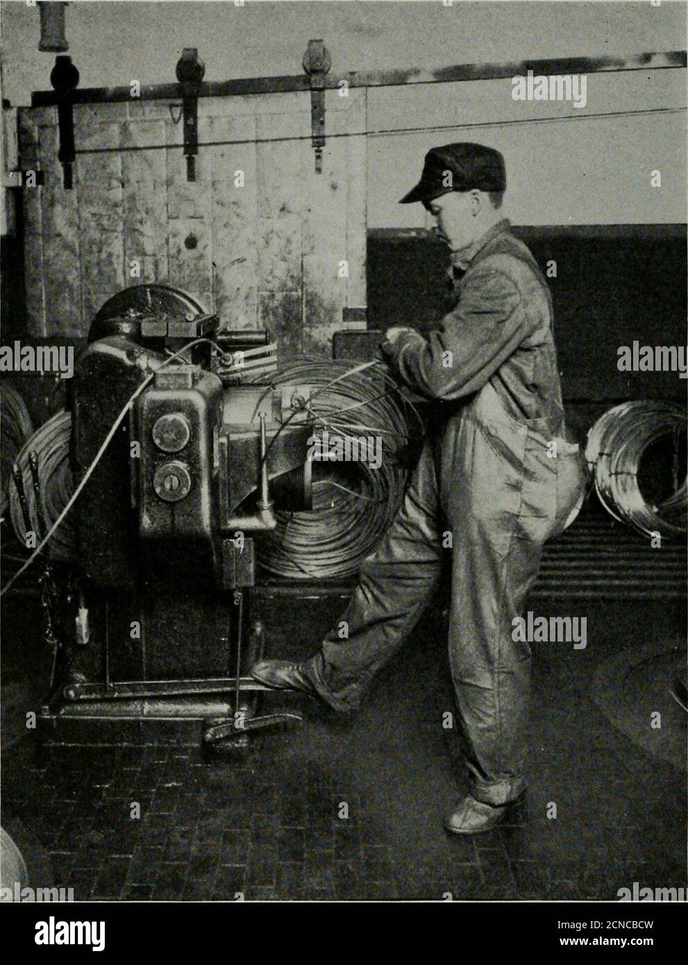 . Il perno tecnico Bell System . le macchine di trafilevengono tirate in posizione all'estremità di partenza della bobina di asta su una macchina di diestringimento (Fig. 10). La bobina, w4th stampi stung in posizione,viene quindi collocata in una macchina trafilatrice di fili pesanti. Su questa macchina vengono trafilati con sé i pesanti calibri di filo, come il filo di linea; Le dimensioni medie, usate nel cavo coperto di piombo, sono aremade prendendo il filo come viene dalla macchina pesante e re-lacca l'acqua è relativamente priva di sali minerali che corroderebbero la barra e influenzerebbero il composto di trafilatura del filo. 198 DISEGNO tecnico DEL SISTEMA CAMPANA i Foto Stock