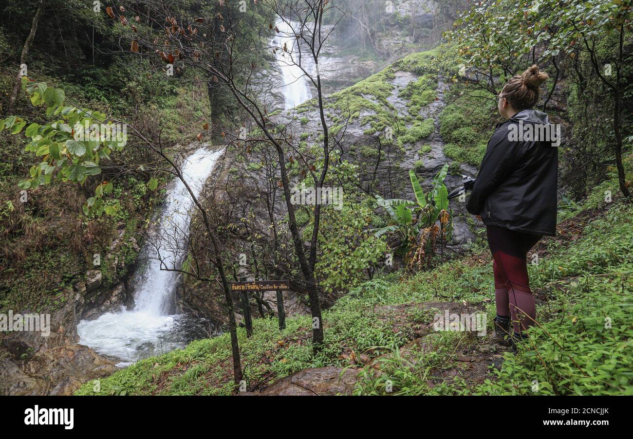 DOI INTHANON NATIONAL PARK, TAIWAN - 03 settembre 2019: Una escursionista femminile si prende nella potente cascata di Mae Pan nascosta nella rurale Doi Inthanon Natia Foto Stock