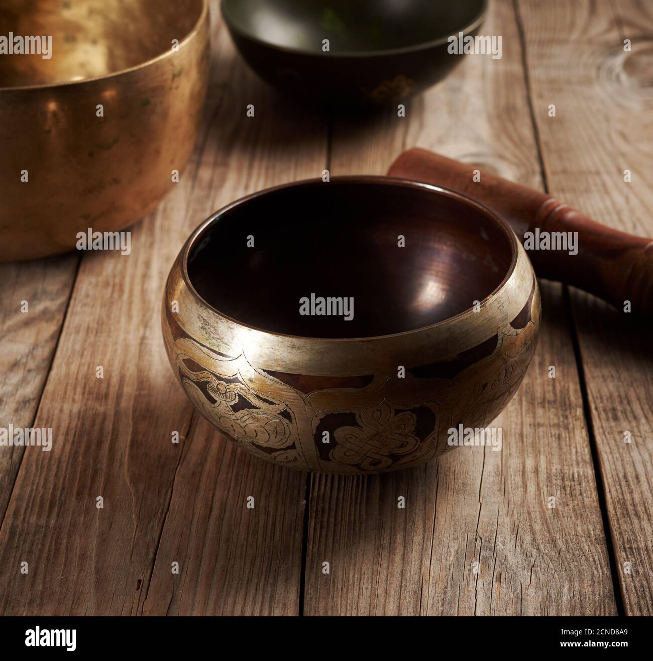 Coppa di rame tibetana cantata con un clapper di legno su un tavolo di  legno marrone Foto stock - Alamy