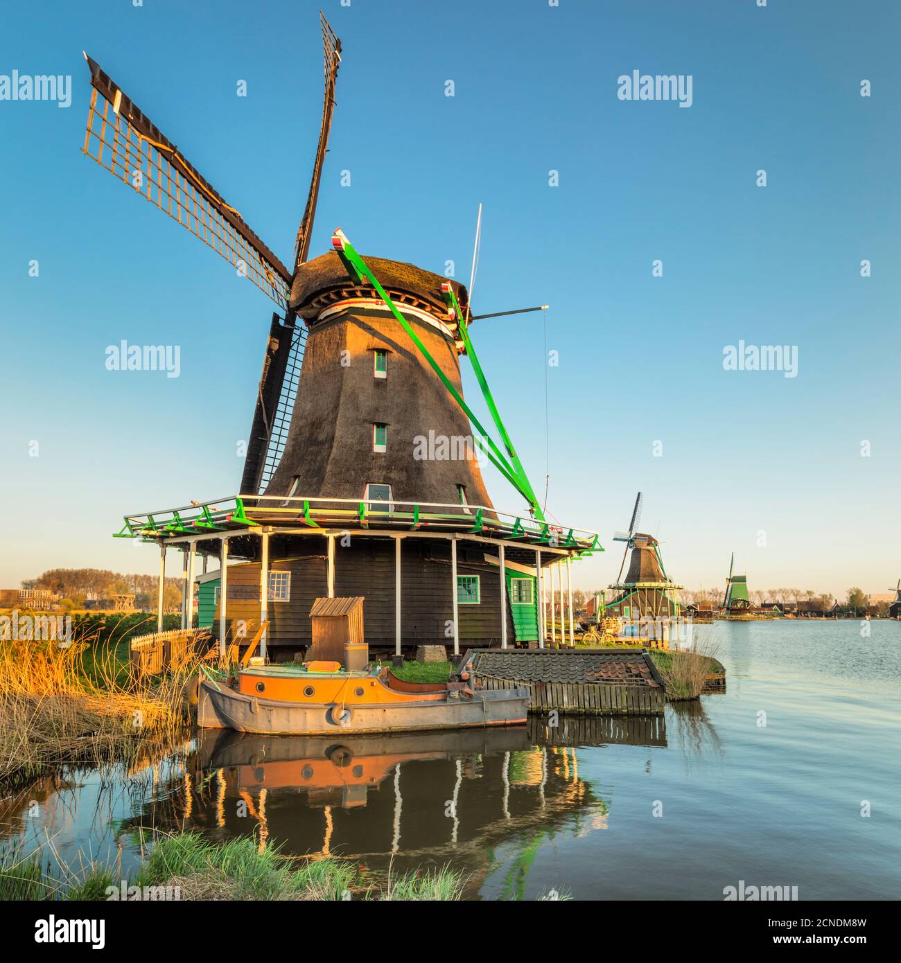 Mulino a vento e barca sul fiume Zaan, museo all'aperto, Zaanse Schans, Zaandam, Olanda del Nord, Paesi Bassi, Europa Foto Stock