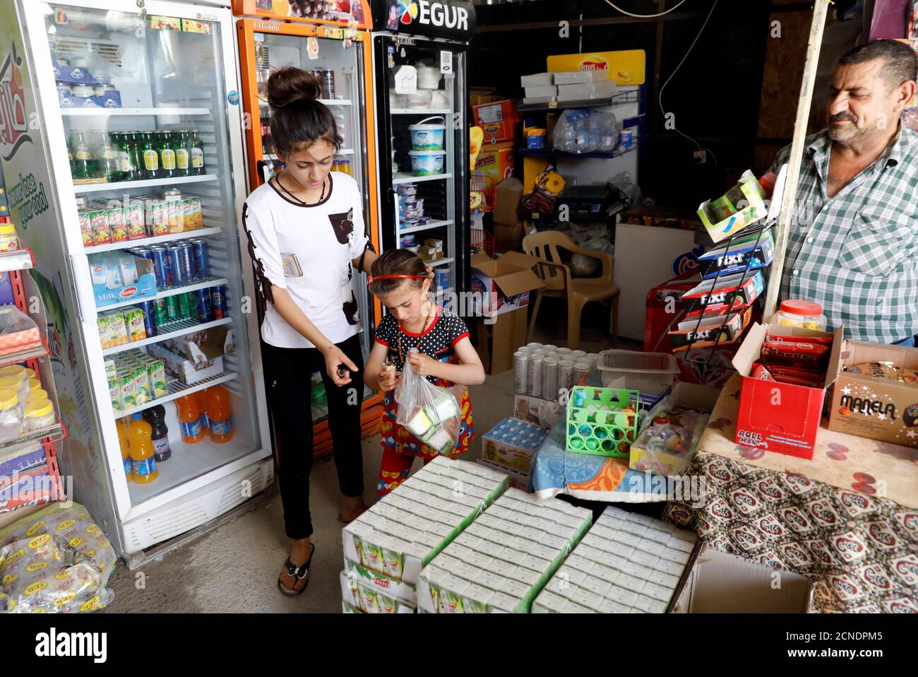 L'iracheno Christina Ezzo Abada, ex ostaggio di militanti dello Stato islamico per tre anni, acquista gelati in un negozio locale in un campo profughi a Erbil, Iraq, 10 giugno 2017. REUTERS/Erik De Castro Foto Stock