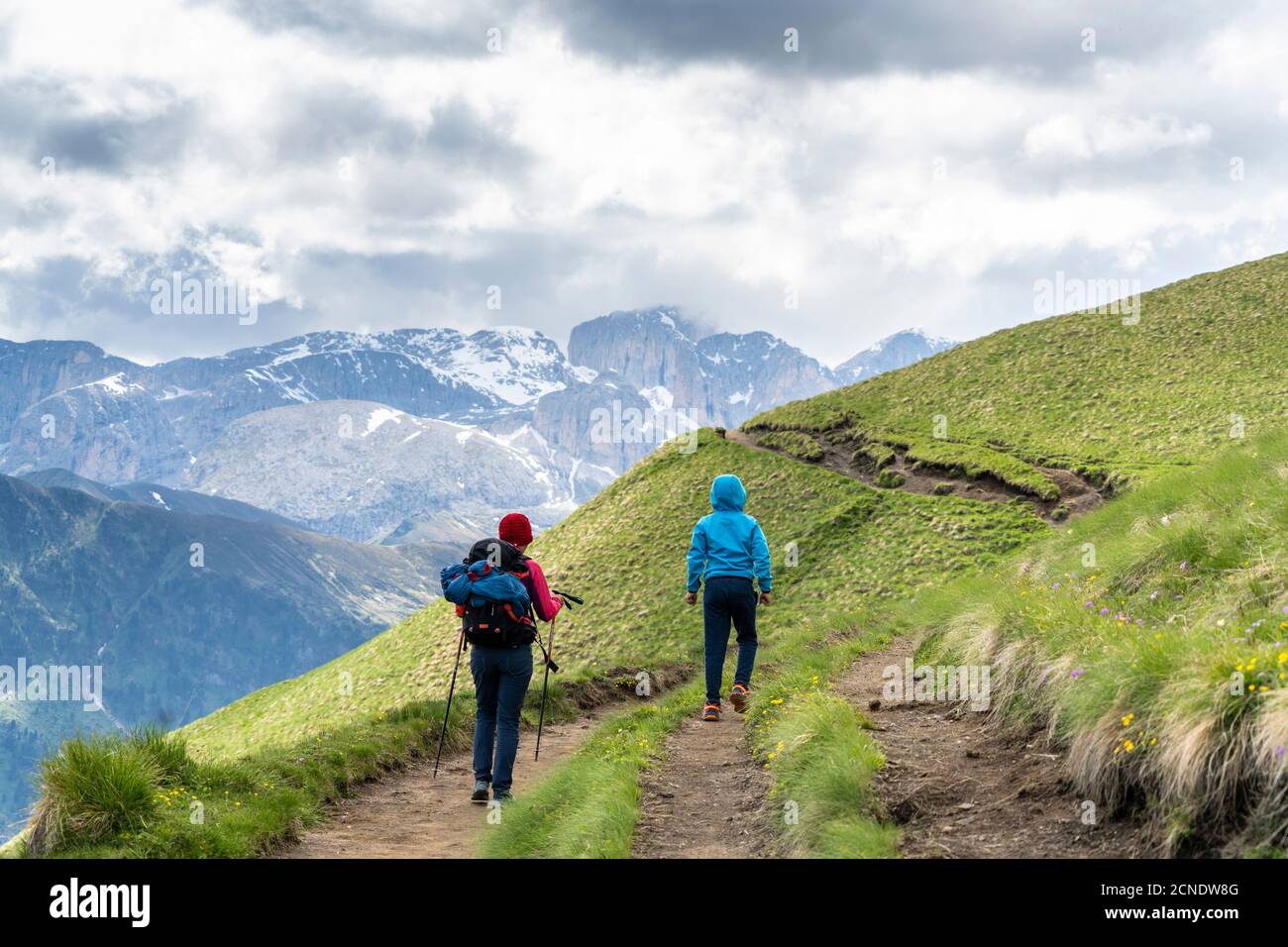 Vista posteriore di madre con bambino maschile trekking intorno al gruppo Sassolungo, Dolomiti, Trentino-Alto Adige, Italia, Europa Foto Stock