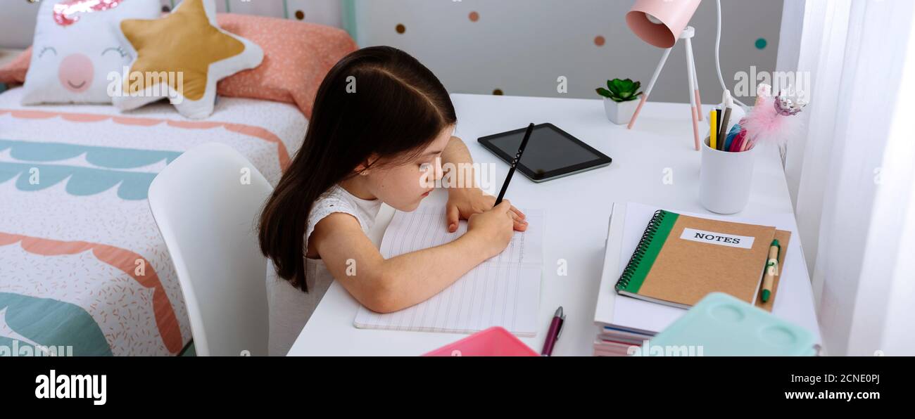 Ragazza che fa i compiti nella sua camera da letto Foto Stock
