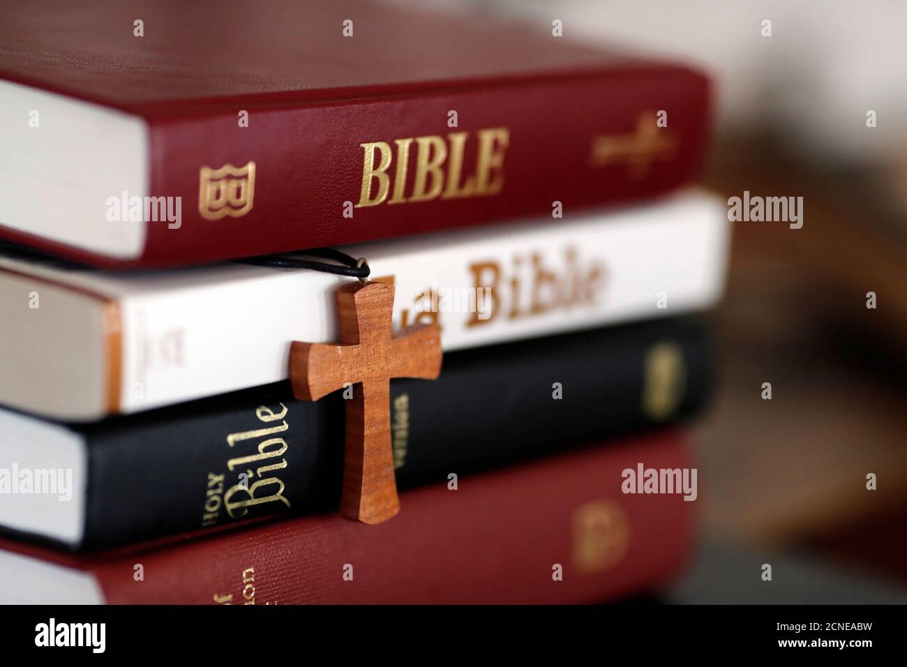 Quattro Bibbie diverse e una croce cristiana su un tavolo, Francia, Europa Foto Stock