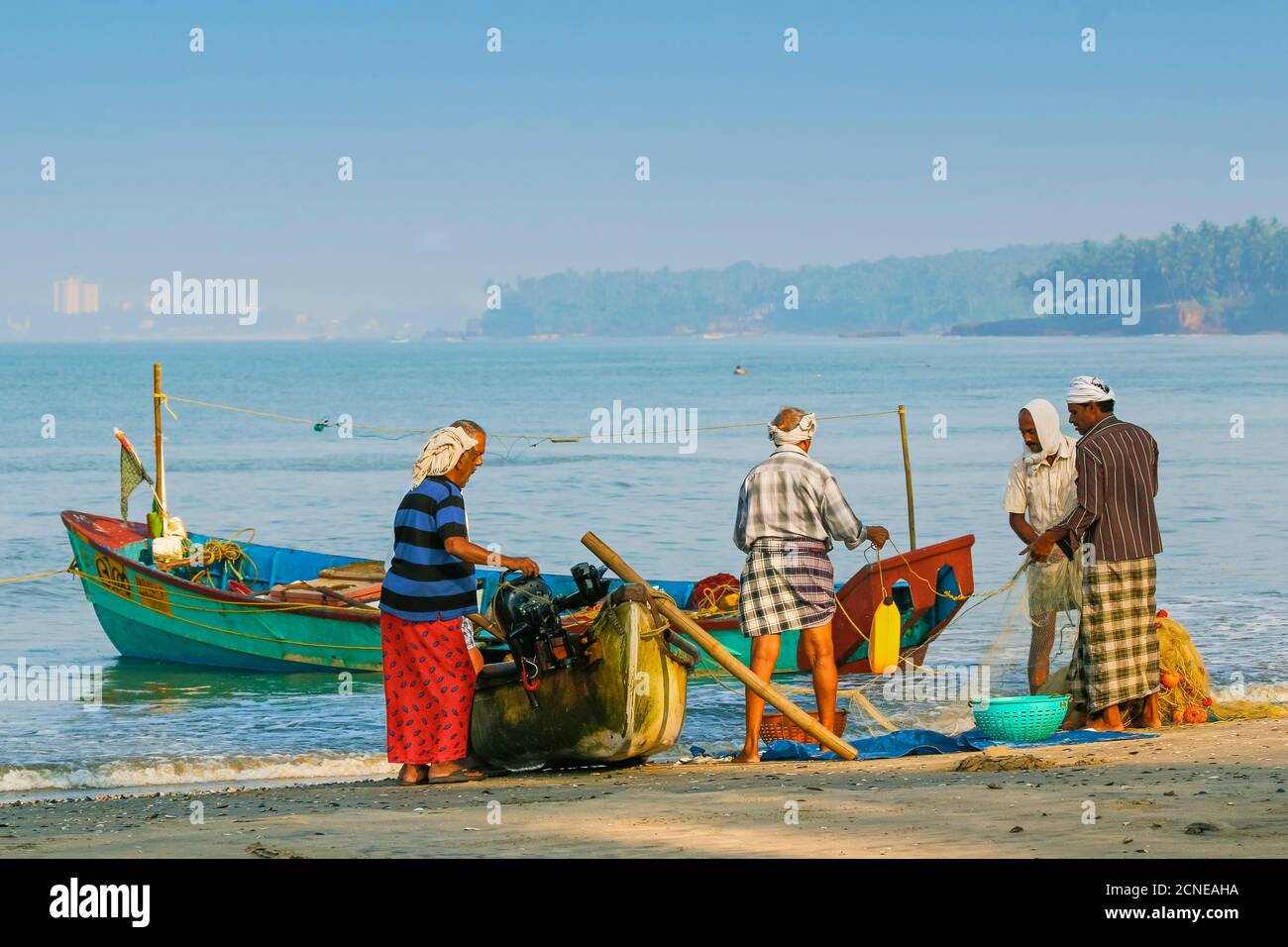 I pescatori puliscono la rete alla bella spiaggia di Kizhunna, a sud di Kannur sulla costa settentrionale del Keralan, Kizhunna, Kannur, Kerala, India, Asia Foto Stock