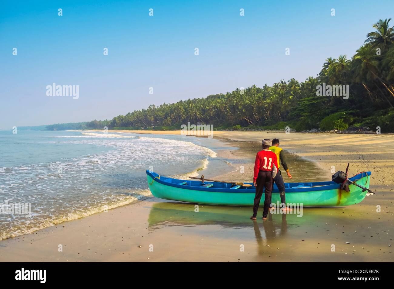 Pescatori con barca sulla bella spiaggia di Kizhunna, a sud di Kannur sulla costa settentrionale del Keralan, Kizhunna, Kannur, Kerala, India, Asia Foto Stock