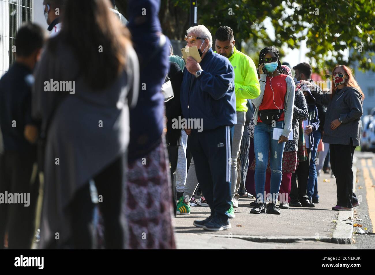 Le persone si accodano fuori da un centro di test del coronavirus che offre appuntamenti walk-in nel nord di Londra. Foto Stock